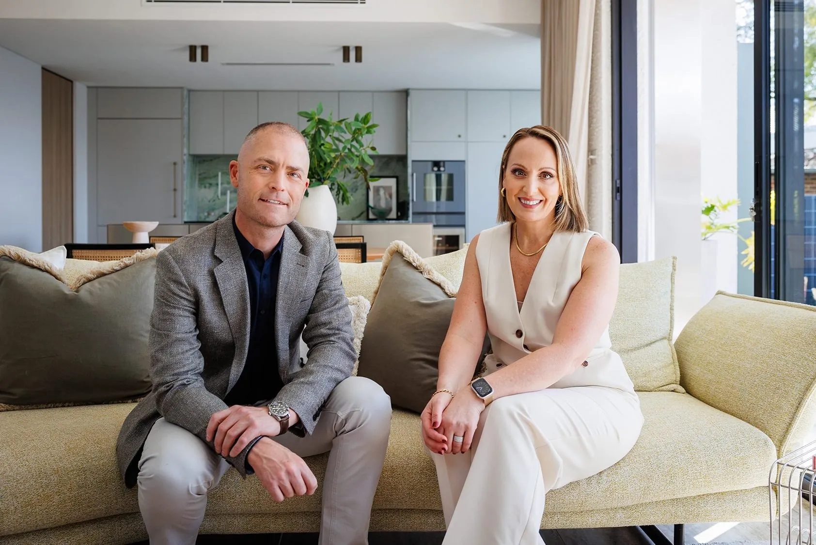 Nadija and Dan on a sofa in a styled living room